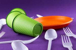 Plastic orange and green waste collection on purple background photo