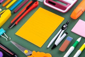 School office supplies stationery on a green background desk with copy space photo