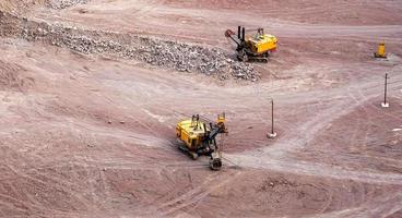 Excavator in a quarry extracting and moving stone photo