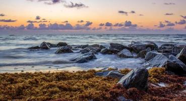 rocas negras junto al cuerpo de agua en la hora dorada foto