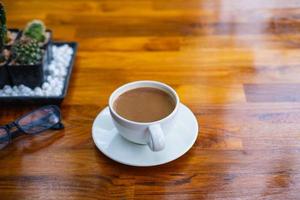 A cup of coffee on a wooden table in a coffee shop photo