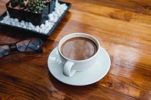 A cup of coffee on a wooden table in a coffee shop photo