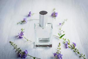 Perfumes y frascos de perfume sobre un fondo de madera blanca foto