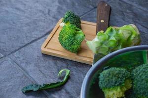 Raw broccoli cut in a wooden chopping board photo