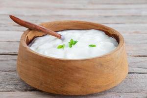 Yogur natural saludable en una mesa de madera foto
