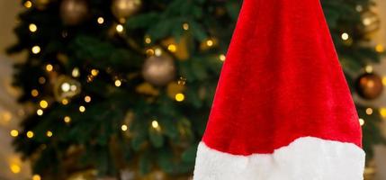 gorro de Papá Noel en el fondo de un árbol de navidad y guirnaldas foto