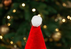 Santa hat on the background of a Christmas tree and garlands photo