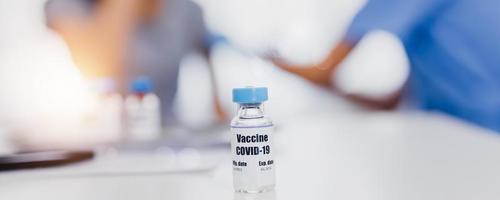 Las vacunas covid en la mesa La pandemia de la enfermedad del coronavirus y las vacunas salvan millones de vidas El concepto con el médico está inyectando a las personas Antecedentes