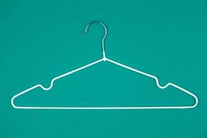 White clothes hanger on turquoise background photo