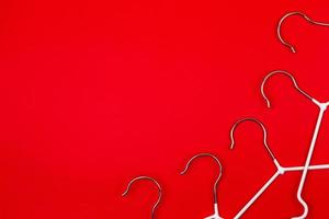 White clothes hangers on red background photo