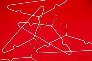 White clothes hangers on red background photo