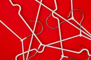 White clothes hangers on red background photo