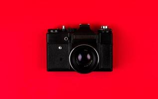 Flat lay film camera isolated on red background photo