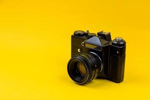 Flat lay film camera isolated on yellow background