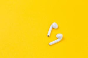 White earphones on yellow background with copy space photo