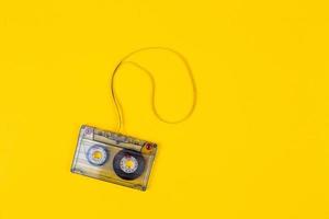 Top view of audio cassette with tangled tape on bright yellow background with copy space photo