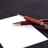 Luxury pen and mechanical pencil in wood and gold with a white sheet of paper photo