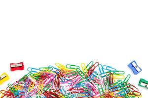 A lot of colored paper clips and pencil sharpeners on a white background