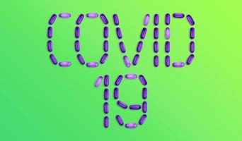 Covid 19 word made up of medicine pills on green background photo