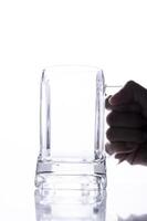 Empty Beer Glass with hand holding on white background photo