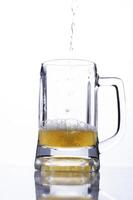 Pour beer into a glass on white background for international beer days photo