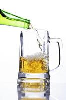 Pouring beer into a glass on white background for international beer days photo