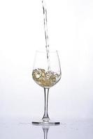 Pouring beer into wine glass on white backgrounds photo