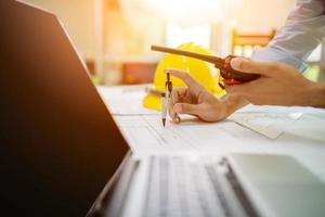 Architect man working with laptop and blueprints photo