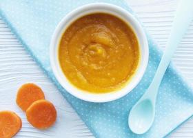 Baby carrot mashed with spoon in bowl photo