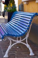 A blue wooden painted bench on the street photo
