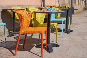 Multi colored chairs on the street terrace of the cafe photo