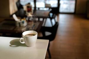 White coffee mug on the table inside the cafe photo