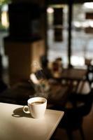 White coffee mug on the table inside the cafe photo