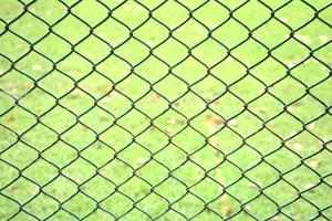 Patrón de eslabones de cadena cerca abstracta con fondo de campo de hierba verde foto