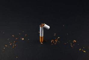 Concepto de romper y dejar de fumar cigarrillos sobre fondo negro grunge foto