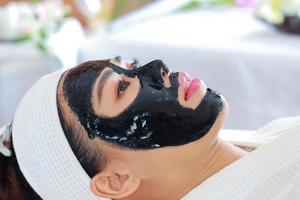 Mujer recibe tratamiento facial de la piel por una esteticista en un salón de spa foto