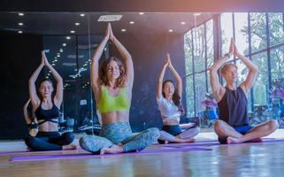 Group exercising yoga in the gym by stretching, healthy exercise concept photo