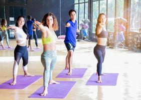 Group practicing yoga in the gym, concept of healthy exercise and meditation photo
