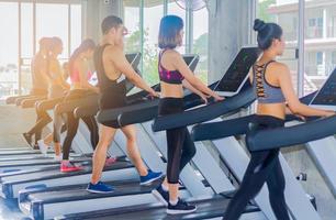 Young group exercises in the gym by jogging on the treadmill photo