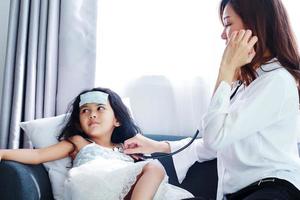 Doctora examinando niña con estetoscopio usado en un hospital foto