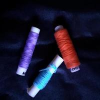 Colored thread on a dark blue background photo