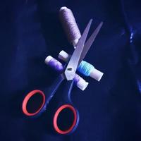 Scissors and thread on a blue background photo