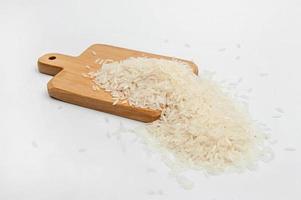 Rice on a wooden table on white background photo