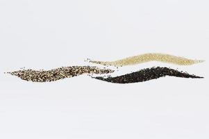 Grains of black tricolor and white quinoa isolated on white background photo