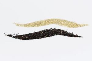 Grains of black and white quinoa isolated on white background photo