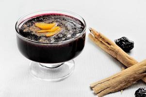 Popular Peruvian desserts called Mazamorra Morada made out of purple corn with cinnamon sticks photo