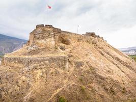 Vista aérea de las murallas del castillo de Gori con banderas de Georgia en la parte superior foto