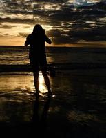 Girl with camera at sunset photo