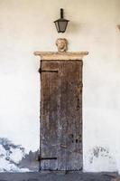 Small wooden door on white wall photo