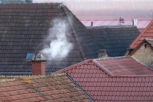 Roofs of an old village with a smoking chimney photo